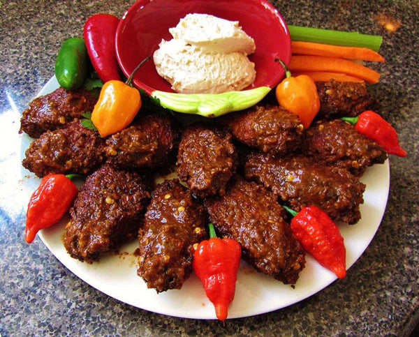 plate of spicy wings coated in hot sauce